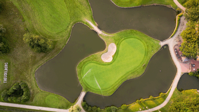 Luftaufnahme des Treudelberg-Golfplatzes mit Wasser, Bunker und Wegen.