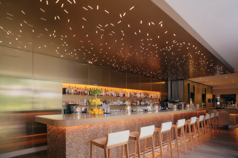 Schicke Hamburger Hotelbar mit goldener Decke, stilvolle Beleuchtung.