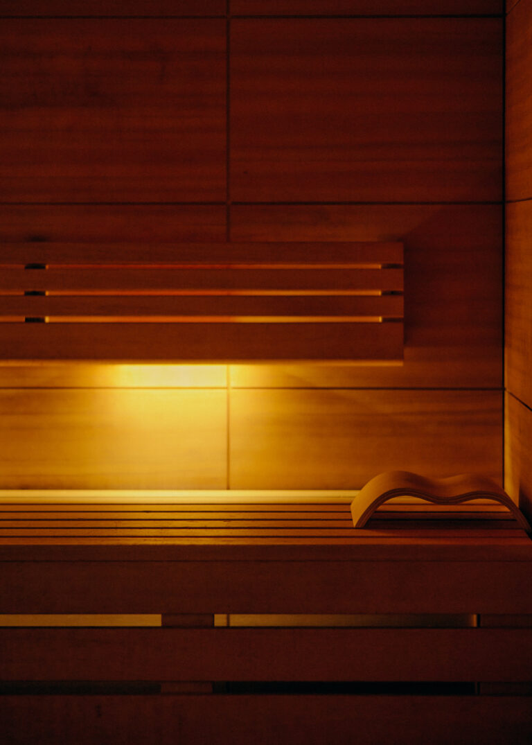 An open book on the sauna bench, warm light - a quiet retreat in the spa.