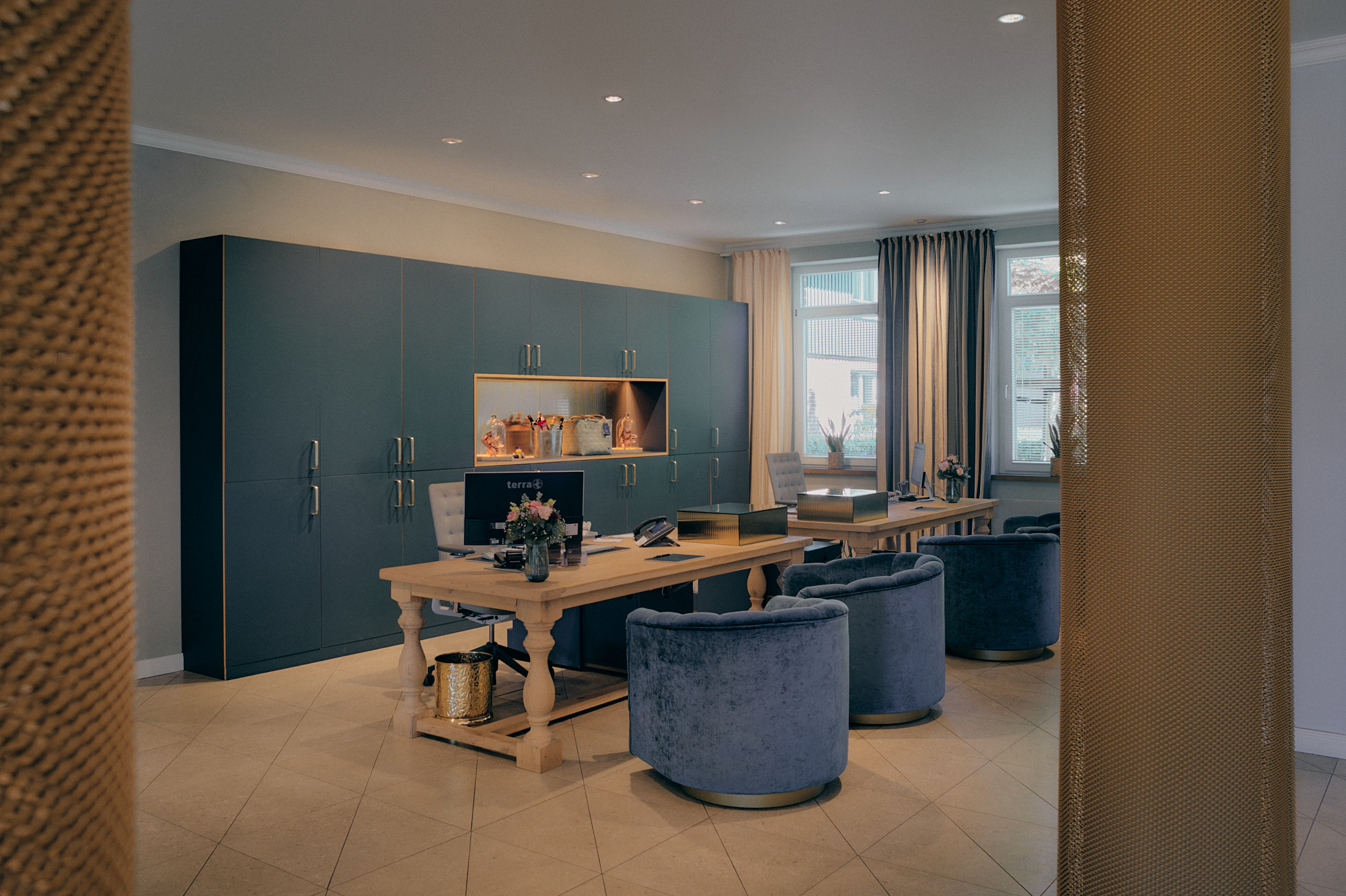Modernes Büro: Holzschreibtische, blaue Stühle, Regale, Fenster - Hamburger Hotelinspiration.