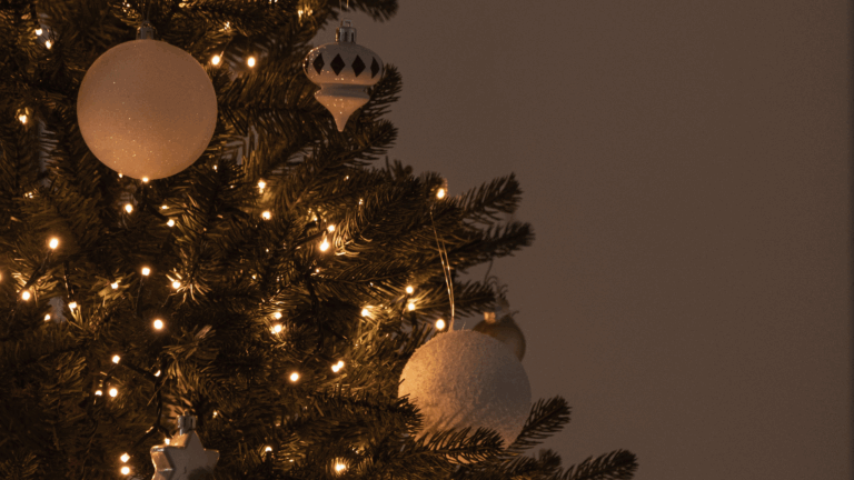 Christmas-tree-decorated-white-ornaments-lights-Christmas-brunch shows a Christmas tree with white ornaments, warm lights and a cozy ambience.